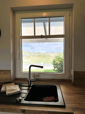Eine Küche mit Fenster, Spüle und einem Handtuch auf der Arbeitsplatte.