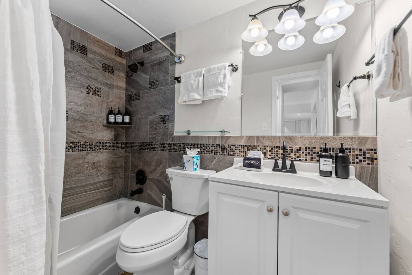 A modern bathroom with a shower, toilet, and vanity.