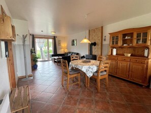Eine gemütliche Küche mit Holzschränken, einem Esstisch mit Stühlen und einer Glastür zum Patio.