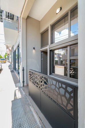 A building with a modern facade, large windows, and a decorative metal fence. - Echo City Loft by Rentals Pro - Nea Moudania Halkidiki (Nea Moudania)