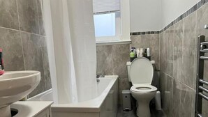Un baño con inodoro, lavamanos y bañera.