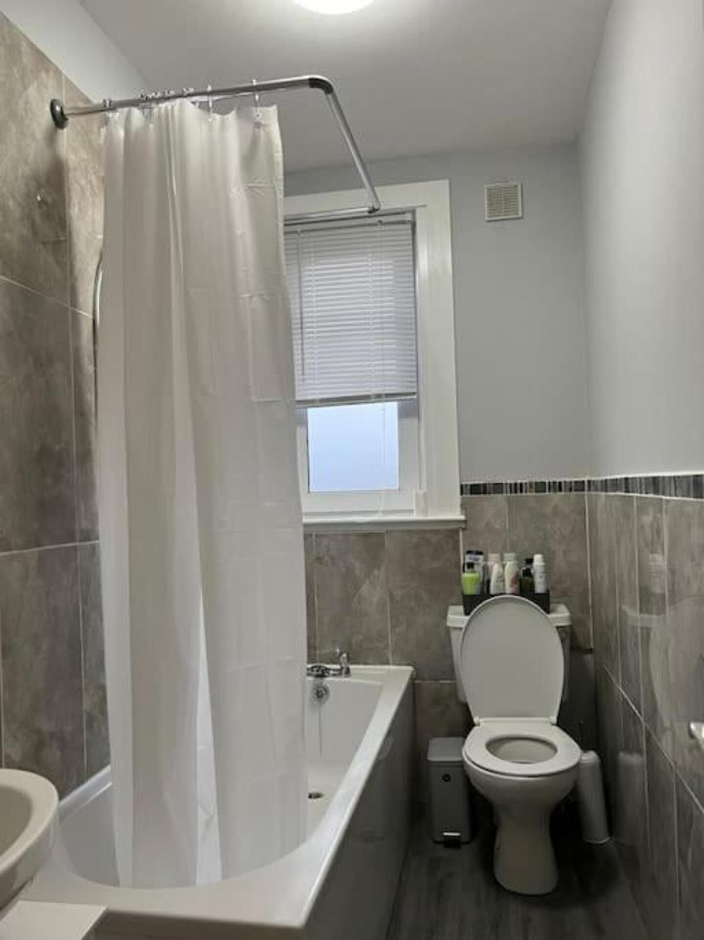 Ein Badezimmer mit Badewanne, Toilette und Duschvorhang.