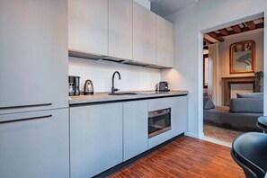 Eine moderne Küche mit integriertem Backofen, einer Kaffeemaschine und einem Spülbecken.