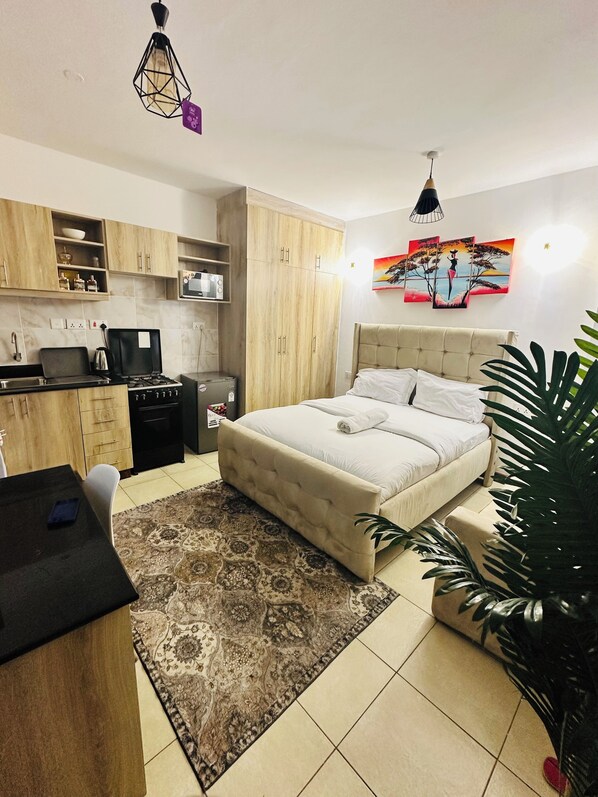 Un dormitorio con cama, mesita de noche y un amplio ventanal.