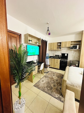 Un espace de vie compact comprenant une kitchenette, un coin repas et un salon.