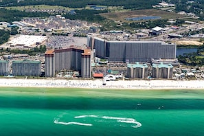 Ein Küstenhotelkomplex mit mehreren Hochhäusern, einem Strand und einer Marina.