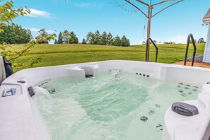 Un bain à remous offrant une vue dégagée sur la zone verdoyante et les arbres environnants.