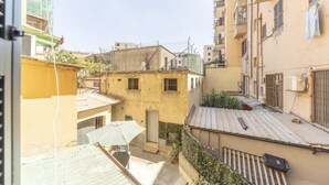 A narrow urban alleyway with buildings on either side, some with balconies and others with ground-level windows. - Delightful little house to discover the truest and most popular Rome in the heart of Pigneto (Roma RM)