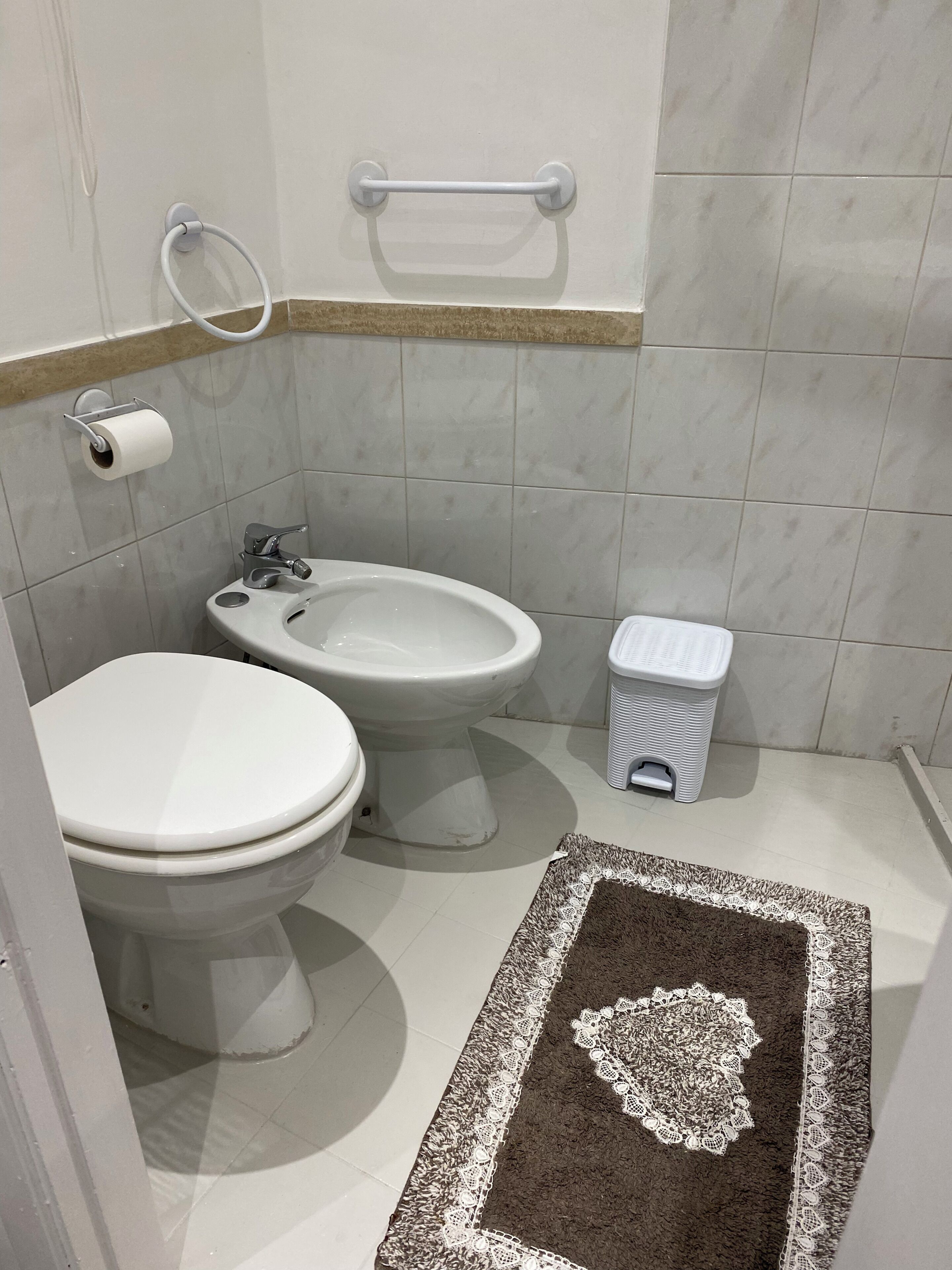 Ein Badezimmer mit Toilette, Bidet und einem kleinen Mülleimer.