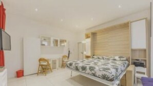 A modern bedroom with a bed, a desk, and a chair. - Delightful little house to discover the truest and most popular Rome in the heart of Pigneto (Roma RM)