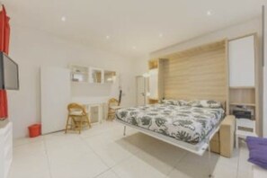 A modern bedroom with a bed, a desk, and a chair. - Delightful little house to discover the truest and most popular Rome in the heart of Pigneto (Roma RM)