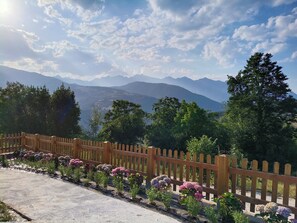 A wooden fence with a view of mountains and a clear sky.