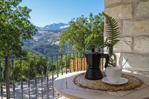 Un balcon avec une machine à café, une tasse et un set de table en fibres tressées.