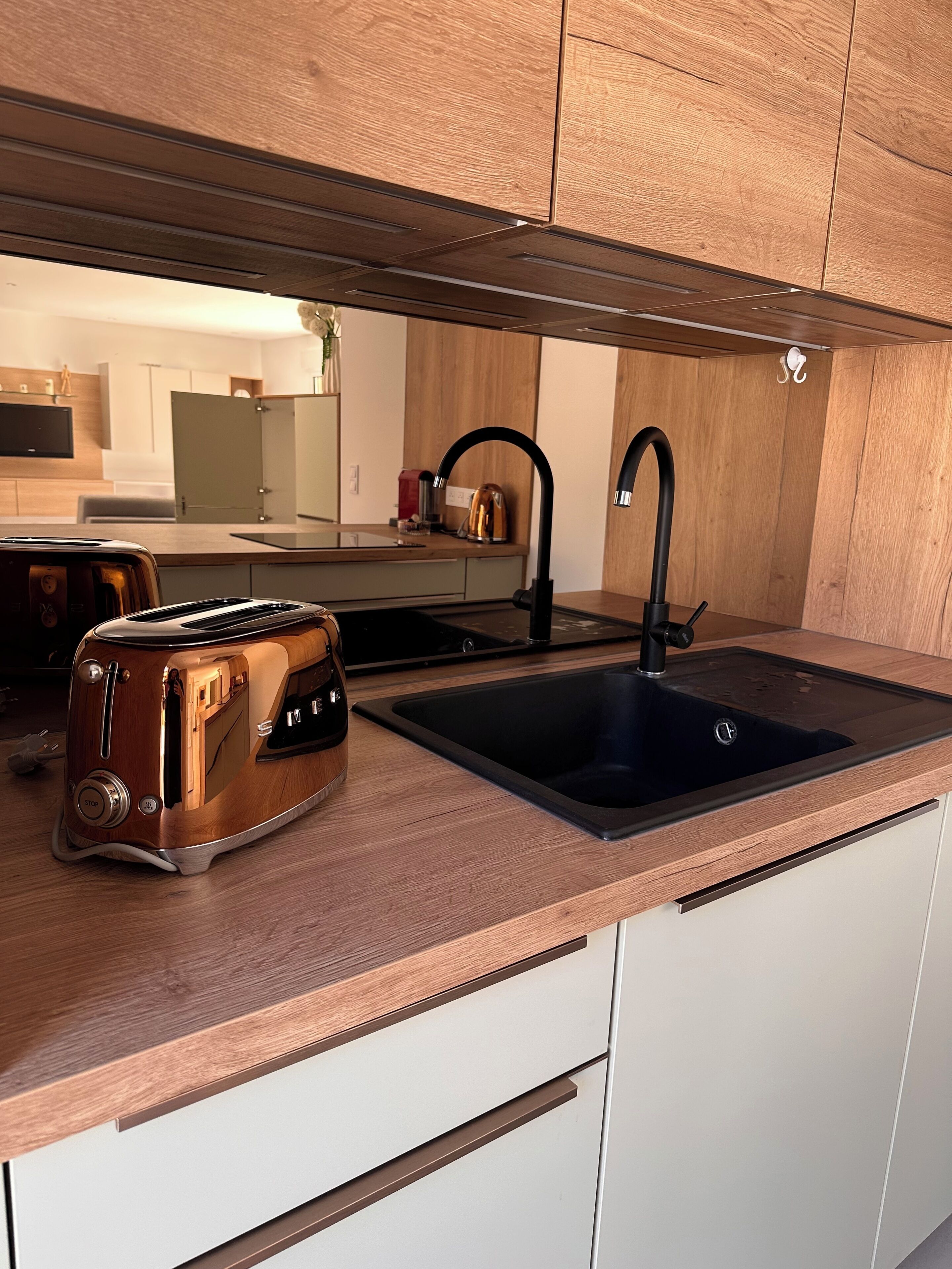 Een moderne keuken met een houten aanrecht, een zwarte spoelbak en een retro toaster.