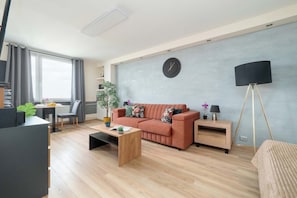 Ein modernes Wohnzimmer mit einer Couch, einem Couchtisch und einer Lampe.