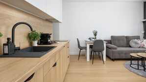 Ett modernt kök med en bänkskiva i trä, en svart diskho och en kaffemaskin.