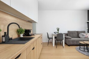 Eine moderne Küche mit Holzarbeitsplatte, einer schwarzen Spüle und einer Kaffeemaschine.