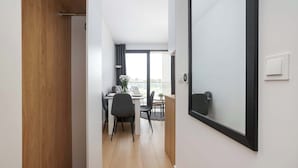 En modern inredning med en trädörr, en matplats med bord och stolar samt ett stort fönster.