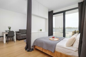 Una camera da letto moderna con un letto, una scrivania, una sedia e vista sull'esterno.