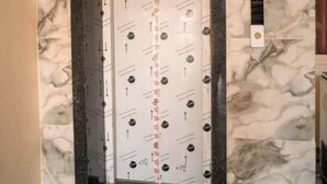 An elevator with a marble wall design, a visible scale, and a security camera above it. - Hotel Shree Karni Palace (Beawar)