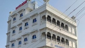 A multi-story hotel with a traditional architectural style, featuring balconies and arched windows. - Hotel Shree Karni Palace (Beawar)