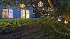 A modern building with large glass doors, a stone staircase, and hanging spherical lights. - Villa Dilù (Maratea)