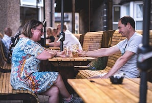 A wooden bench and table in an outdoor seating area.