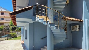 A building with a spiral staircase, a flat roof, and a paved ground. - HotelStina (Rrashbull)