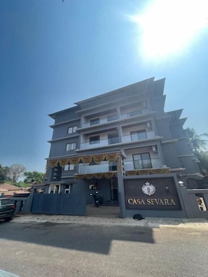 A multi-story building with a gated entrance, a sign reading 'CASA SEVARA,' and a clear sky. - Casa Sevara (Vagator)