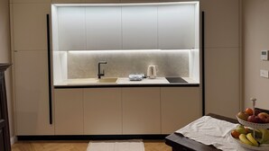 Una cocina moderna con un lavamanos integrado, una tetera y un frutero en la encimera.