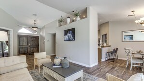 Amplia sala de estar con sofá, mesa de centro y comedor con sillas y una mesa.