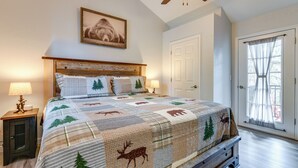 A bedroom with a bed, a ceiling fan, a door, and a window with curtains. - 2-unit Compound w/ Hot Tubs & Views in Gatlinburg! (Gatlinburg)