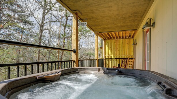 A hot tub with a wooden deck and railings, surrounded by trees. - 2-unit Compound w/ Hot Tubs & Views in Gatlinburg! (Gatlinburg)