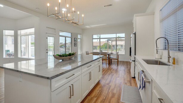 A modern kitchen with a large island, white cabinetry, and a dining area with a view. - Pool + Lakefront: Upscale Glendale Getaway (Glendale)