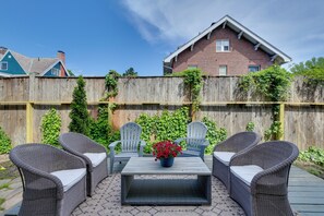 A patio with wicker furniture, a table, and a potted plant. - A Timeless Retreat at Historic Crompton House (Worcester)