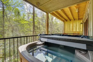 A hot tub with a wooden deck and railing, surrounded by trees. - 2-unit Combo w/ Hot Tubs - Explore Gatlinburg! (Gatlinburg)