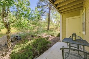 A covered patio with a table and chairs, surrounded by trees and a natural landscape. - Shop, Dine, Hike, Explore Dtwn! Flagstaff Getaway (Flagstaff)