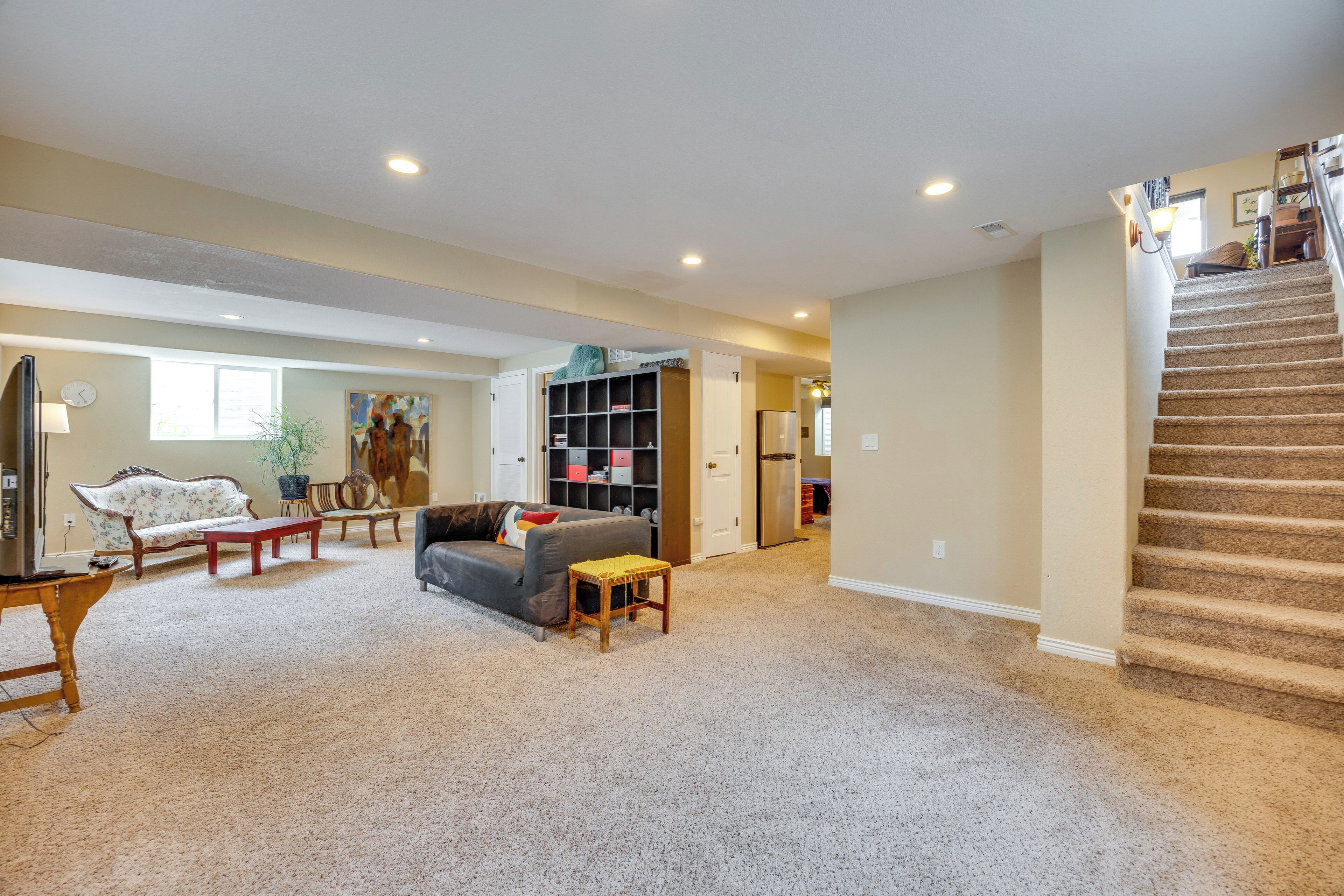 A spacious living room with a sofa, coffee table, and a staircase leading to another level.