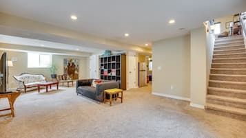 A spacious living room with a sofa, coffee table, and a staircase leading to another level.
