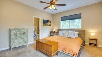 A bedroom with a bed, dresser, ceiling fan, window, and nightstand.