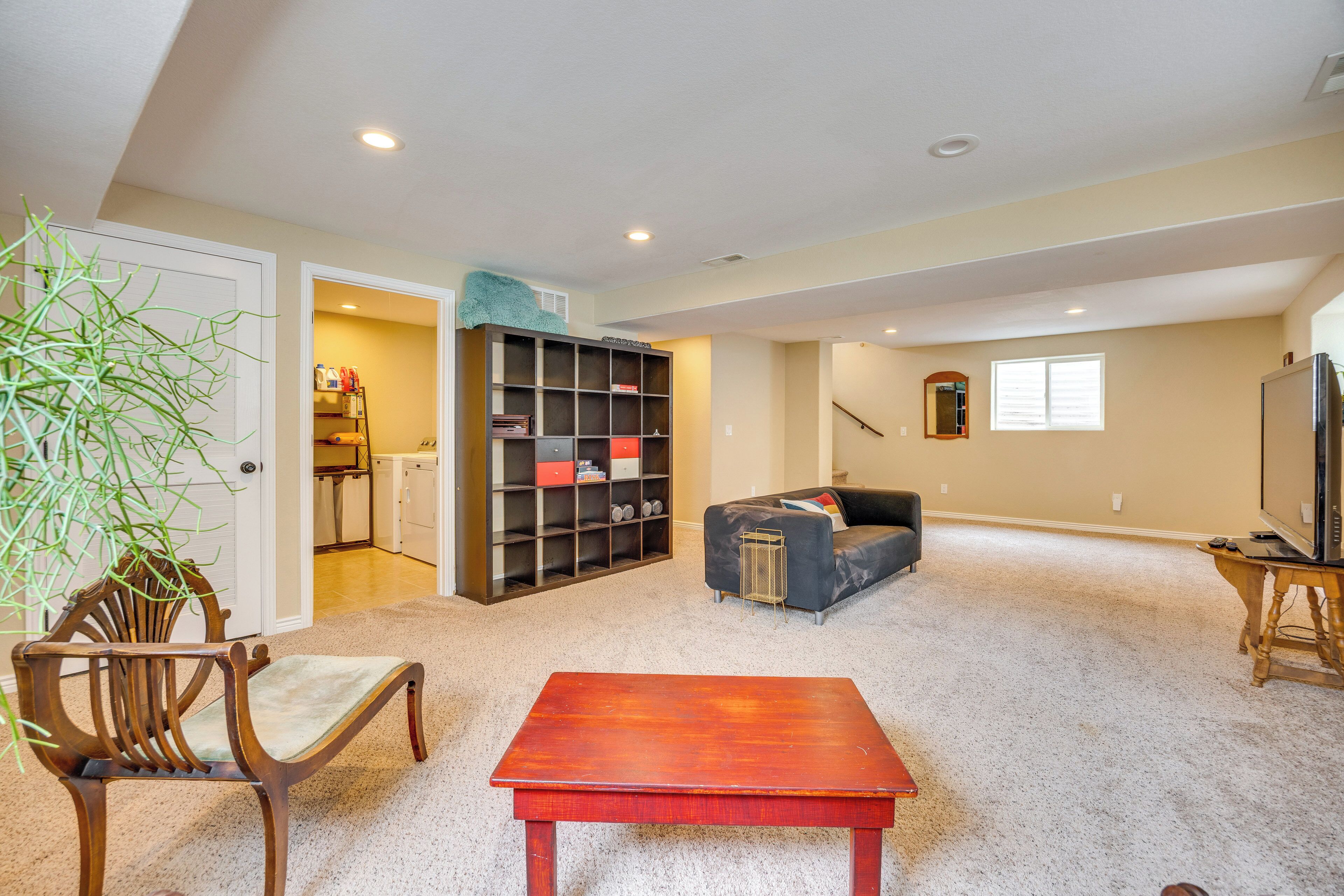 A living room with a sofa, a wooden table, a bookshelf, and a television.