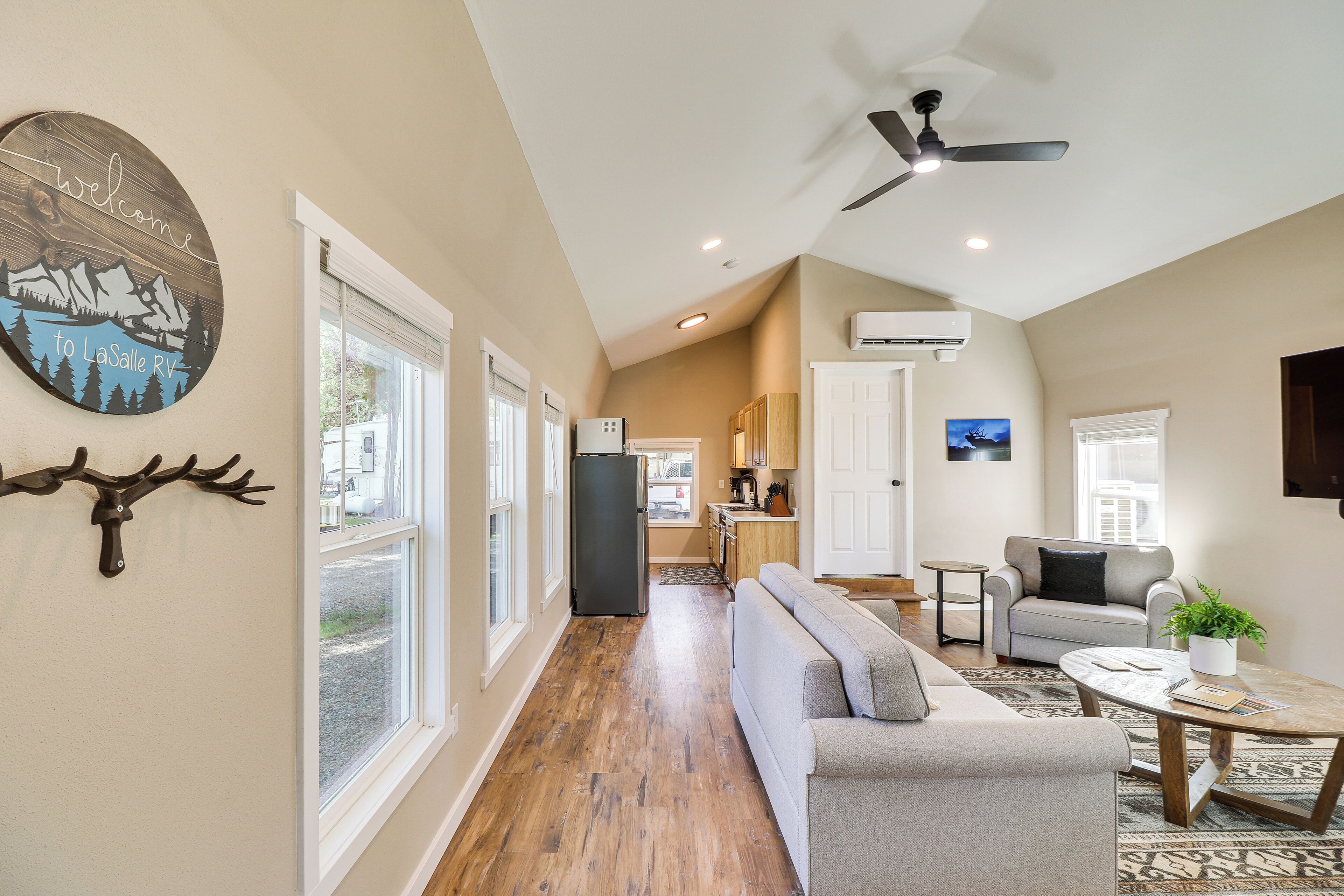A spacious living area with a sofa, a coffee table, and a ceiling fan.