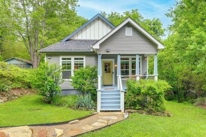 Einbungalow mit einer Veranda, einem kleinen Garten und einem Kiesweg zum Eingang.