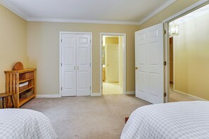 A bedroom with two beds, a wooden cabinet, and a door leading to another room. - 7 Mi to Lake Chatuge! Family Home w/ Office & Yard (Hayesville)