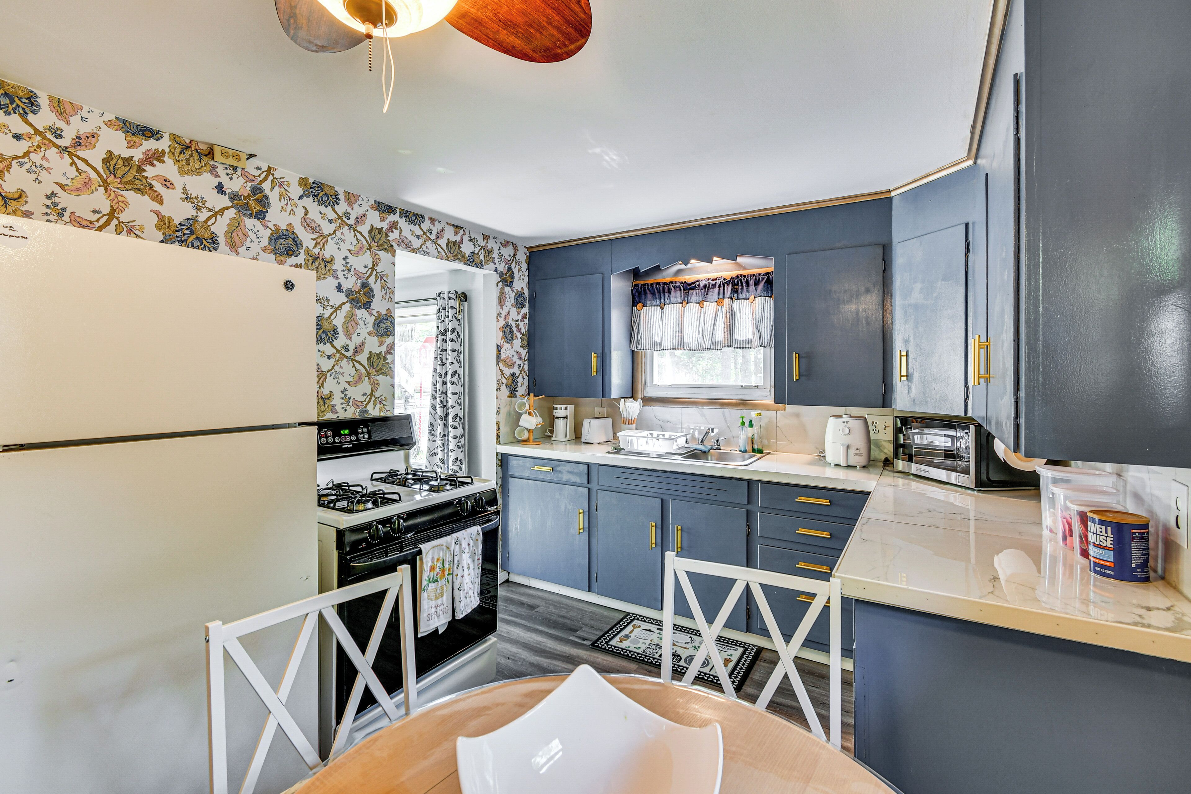 A kitchen with a refrigerator, stove, and cabinets.