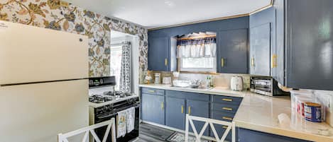 A kitchen with a refrigerator, stove, and cabinets.