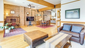A living room with a fireplace, a TV, a sofa, and a dining area with a table and chairs. - Stroll to Main St: Livingston Gem w/ Rooftop Deck (Livingston)