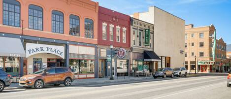 A street with various storefronts including a bakery, a park place, and a cafe.