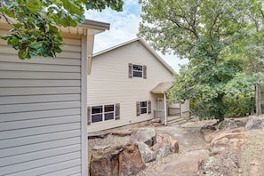 A two-story house with a front porch, a stone pathway, and a large tree. - Sunset View Deck! Lake Eufaula Family Getaway (Stigler)