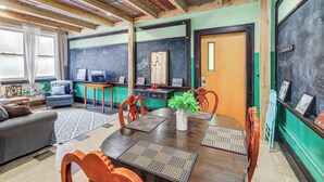 A dining area with a wooden table, chairs, a vase with a plant, and a chalkboard wall. - 'old School ATV Retreat' On Warrior Trail, 8BR (Gary)